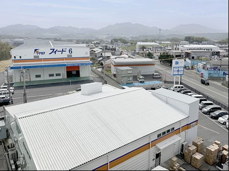 株式会社フィードの工場と周辺の街並みを上空から見た様子