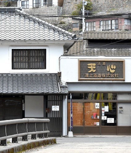 「天心」の看板を掲げた白壁と瓦屋根の溝上酒造の建物